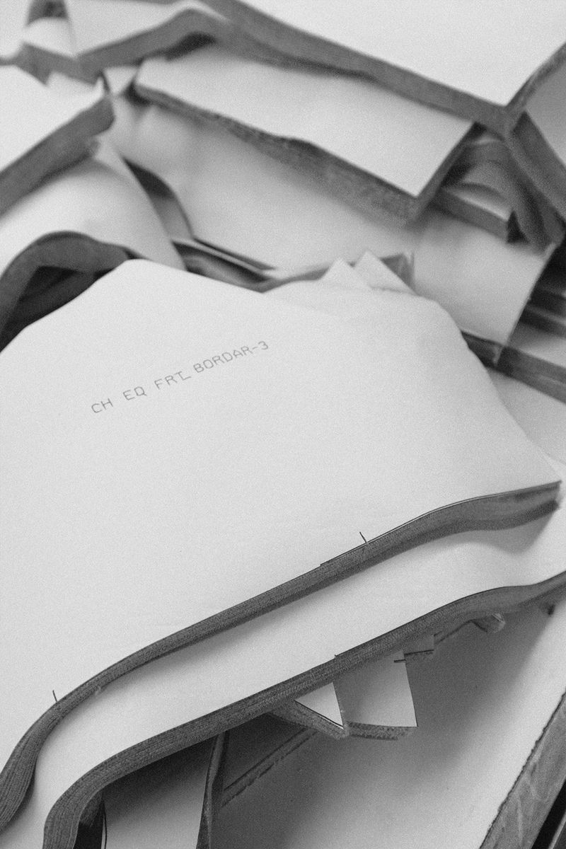 Stack of cut fabric patterns ready for sewing in a textile factory.