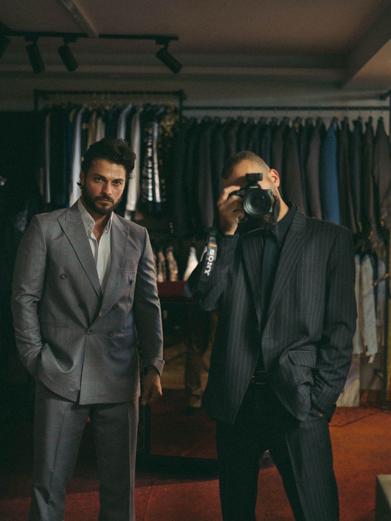 Two men in suits in a fashion boutique setting.
