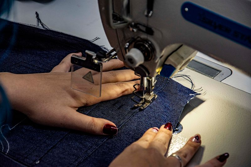 Detailed shot of sewing denim fabric on a sewing machine.