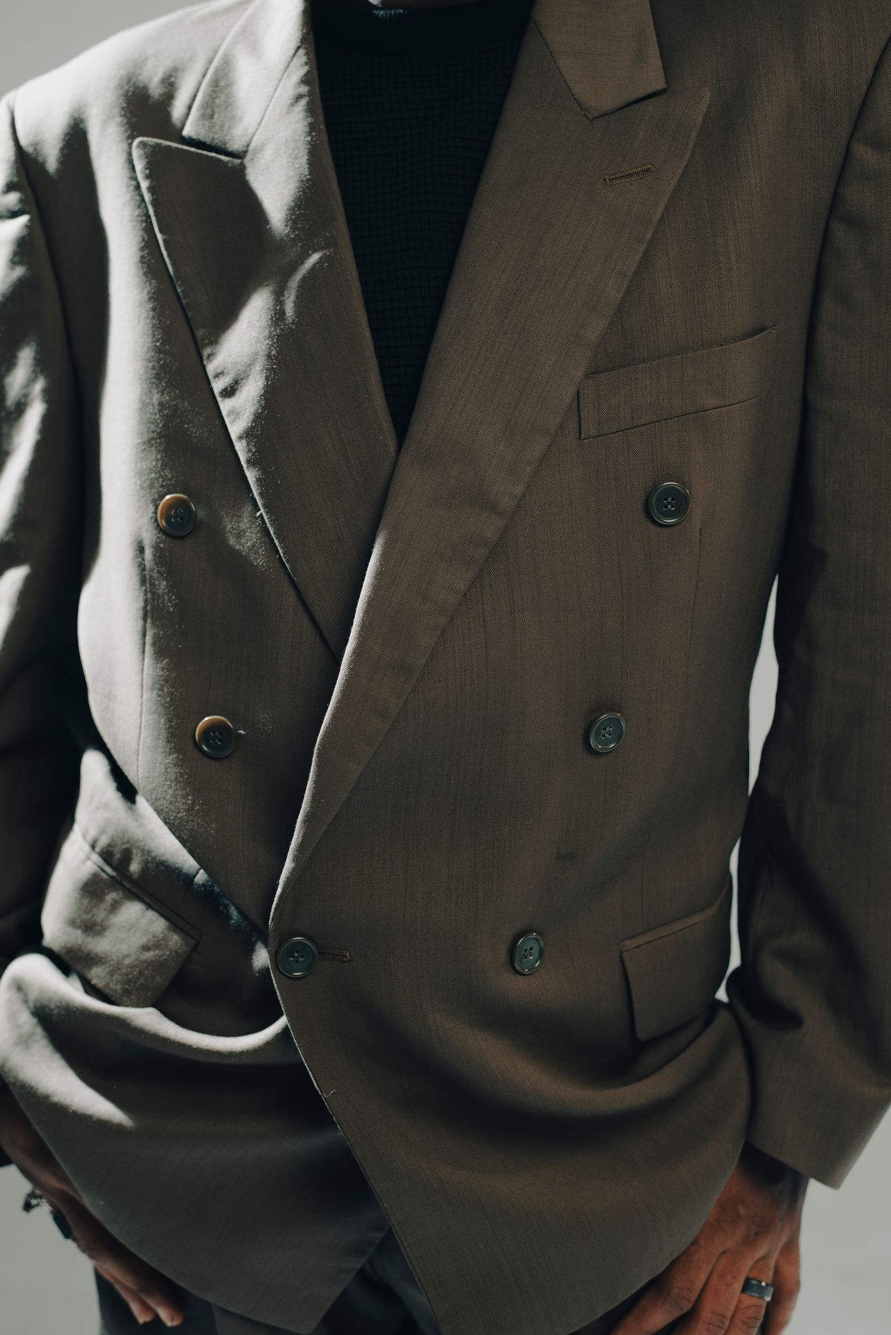 Close-up of a stylish double-breasted blazer with moody lighting.