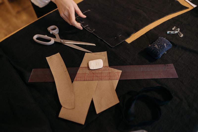 A sewing workspace featuring scissors, patterns, and a measuring ruler.